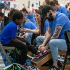 Photo of Genesco Employees Fitting Students with New Shoes at Ida B. Wells Elementary School in Nashville Available on Business Wire's Website and the Associated Press Photo Network